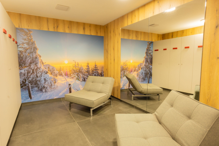 Ein Raum mit Sitzgelegenheiten, einem großen Spiegel und einem großen Bild an der Wand