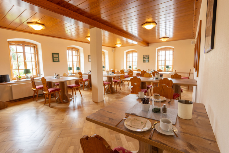 Einblick in den Gastraum mit Tischen und Stühlen