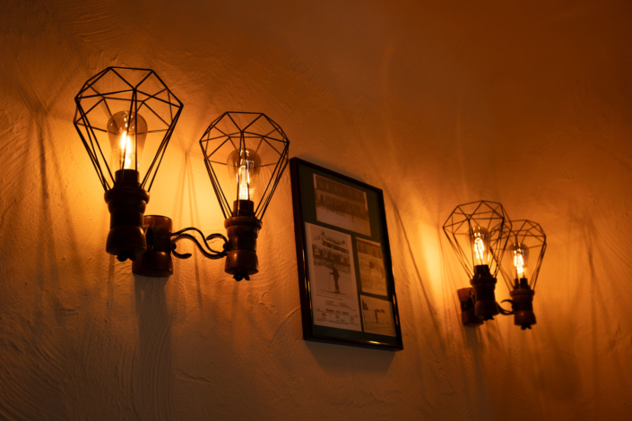 Eine Wand mit 4 Lampen und dazwischen einem Bild