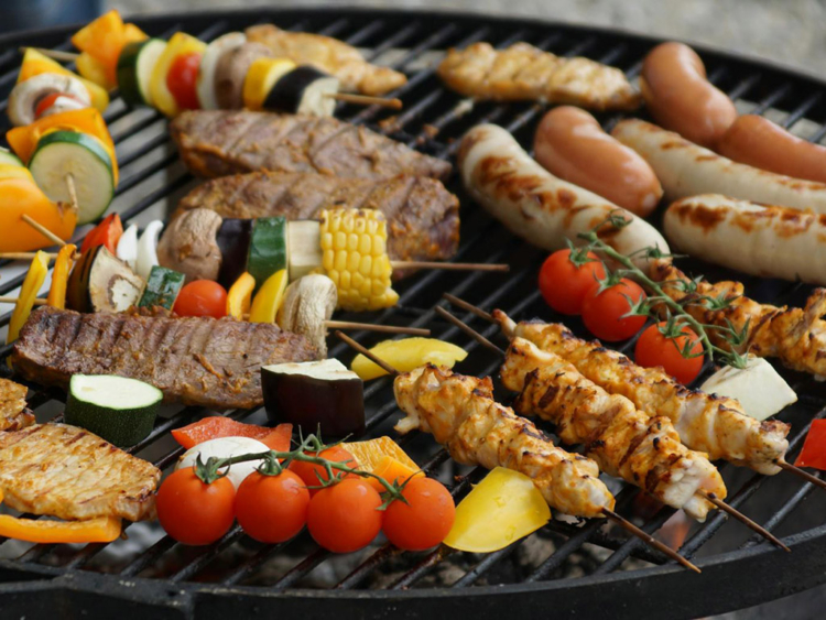 Grill mit Fleisch, Fleischspießen und Gemüsespießen